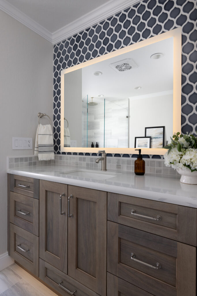 San Jose bathroom remodel with wood vanity with white top and blue tiles on wall with large mirror