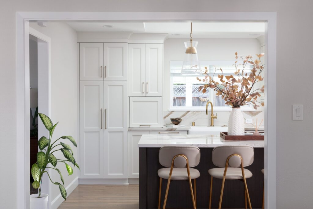 custom white cabinetry with gold finishes in remodeled kitchen
