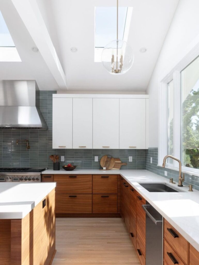 Modern blue-green backsplash with wooden cabinetry, skylights and huge windows