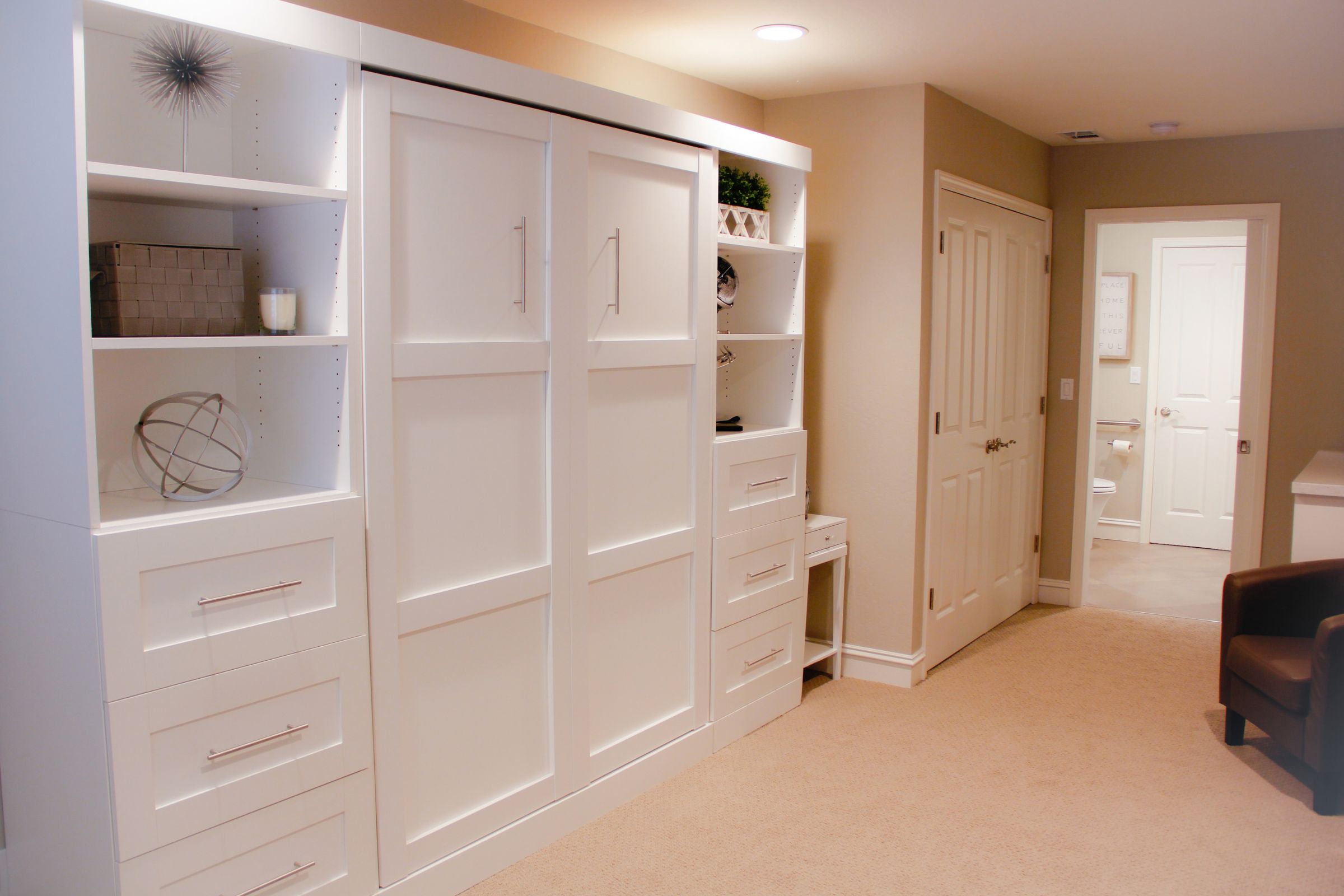 Updated space with small desk and a large built-in shelving unit