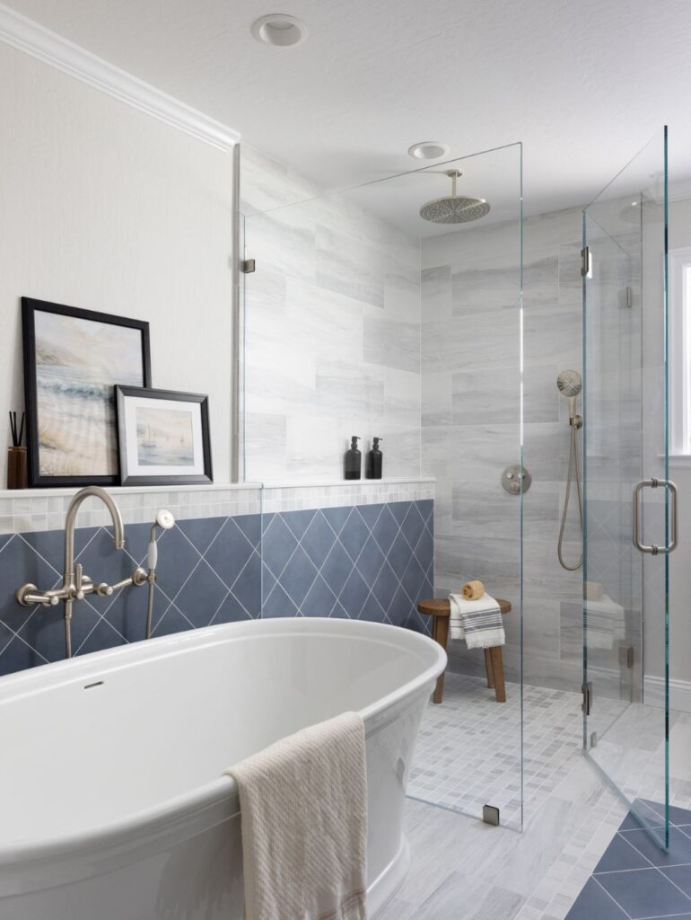Bathroom with a freestanding white bathtub, a glass-enclosed shower, and blue diamond-patterned wall tiles.